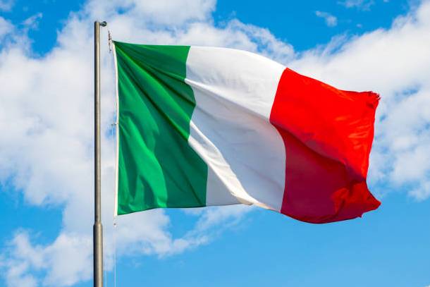 National flag of Italy waving into blue sky